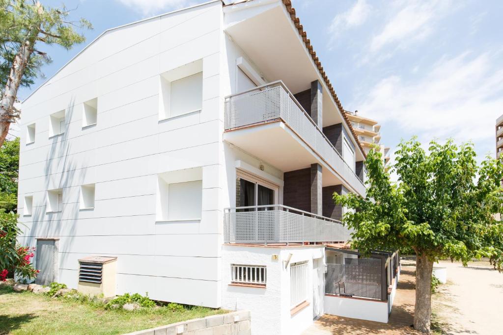 a white building with a balcony at Estudis Laura in Platja d'Aro