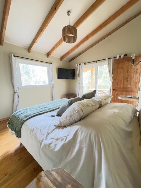 a large white bed in a room with a window at La Magnolia Aldea Molco in Villarrica
