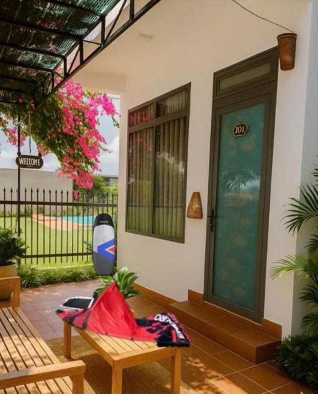 a porch of a house with a bench and a door at Nomad Stay in Phan Rang–Tháp Chàm