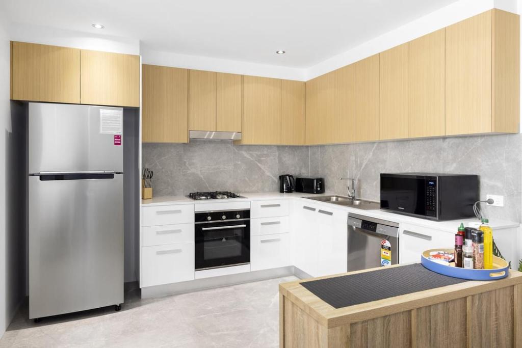 a kitchen with white cabinets and a refrigerator at Marina Retreat in Sandstone Point