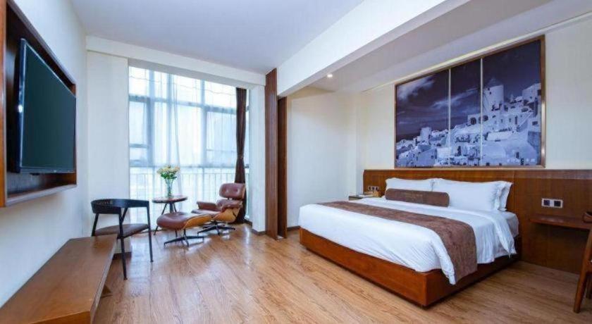 a hotel room with a large bed and a television at James Joyce Coffetel Wuhan Huanlegu Renhe Road Subway Station in Wuhan