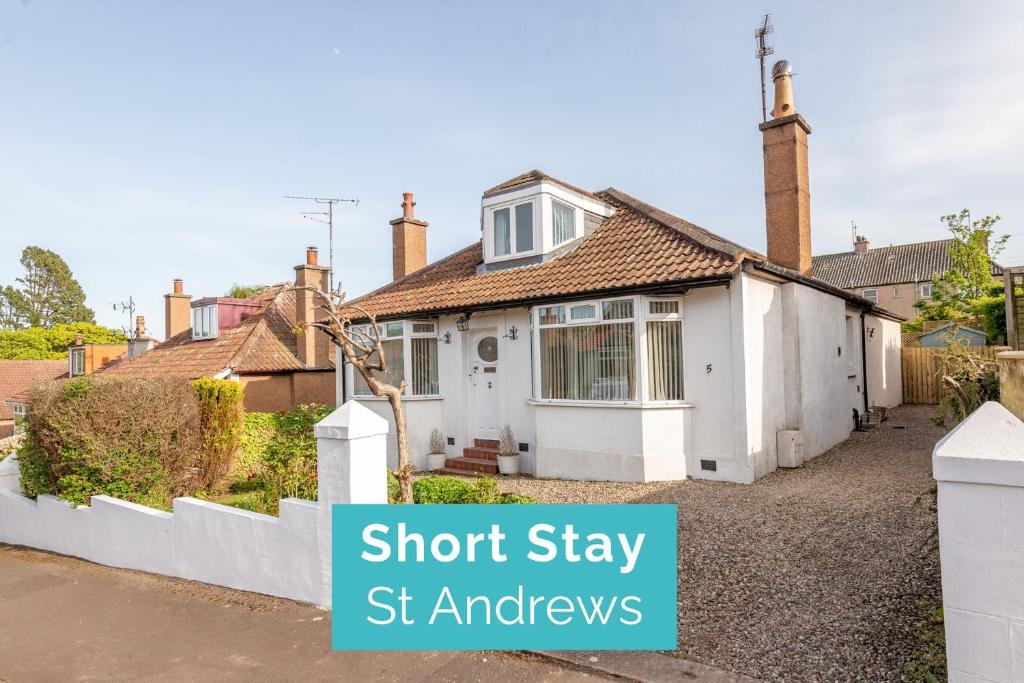 a white house with a sign that says short stay st kitchens at Livingstone Crescent - No 5 in St. Andrews