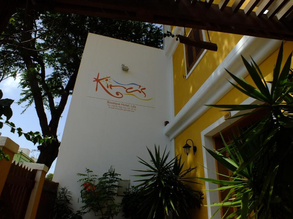a sign on the side of a building with plants at Kira's Boutique Hotel in Mindelo