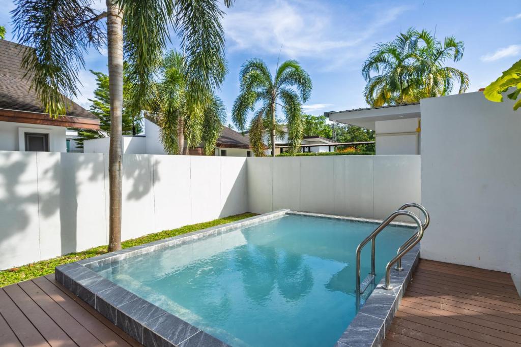 a swimming pool in the backyard of a house with a white fence at New! bayfront 2 BR Villa with private pool Nariya V1 - rare find in Phuket in Ban Bang Chak