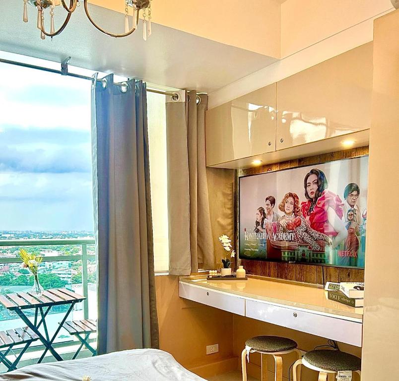 - une chambre avec une télévision à grand écran dans l'établissement The Suites Residences, Azure Luxury Resort, Manila Airport, Wave-Pool, Tropical Vibes, à Manille