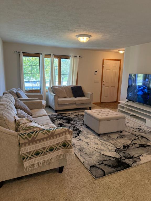 ein Wohnzimmer mit zwei Sofas und einem Flachbildfernseher in der Unterkunft Nice 3-bedroom house located in beautiful neighborhood in Lincoln