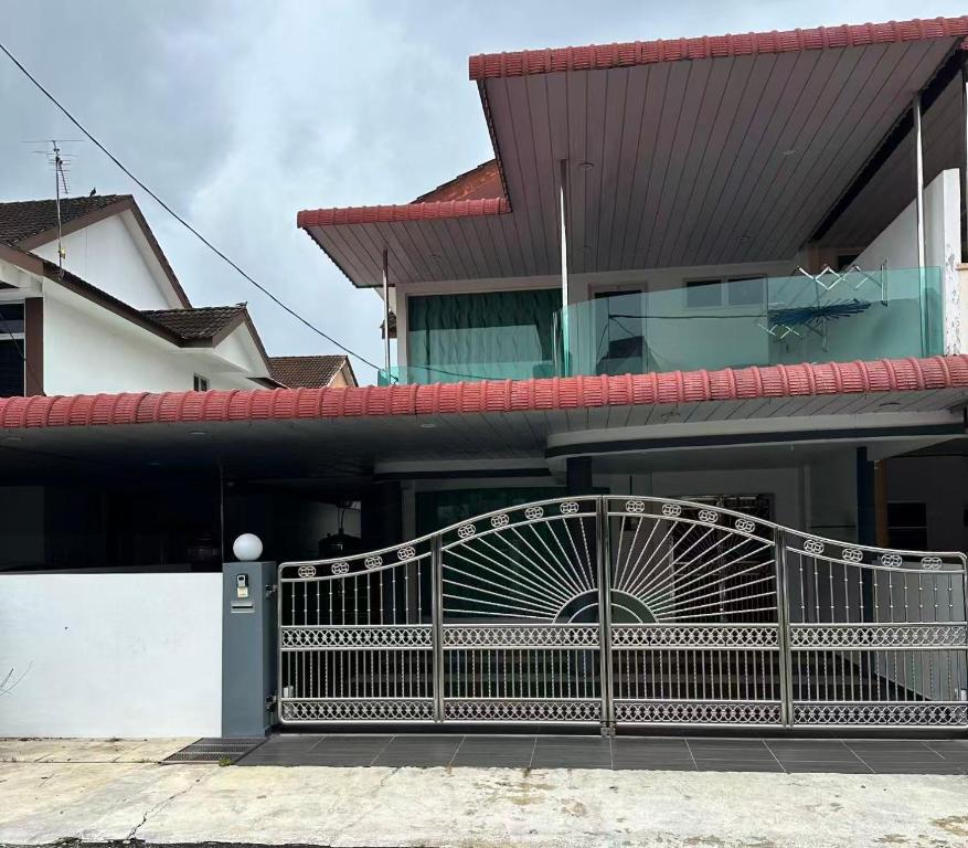 een huis met een hek ervoor bij 家家民宿 in Nibung Tebal