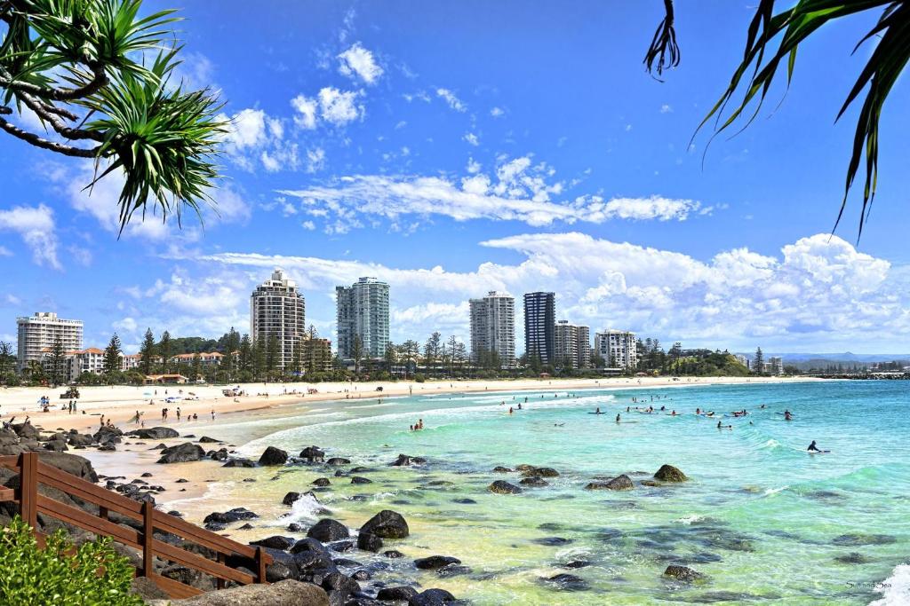 une plage avec des gens dans l'eau et dans les bâtiments dans l'établissement Ocean Plaza Resort, à Gold Coast