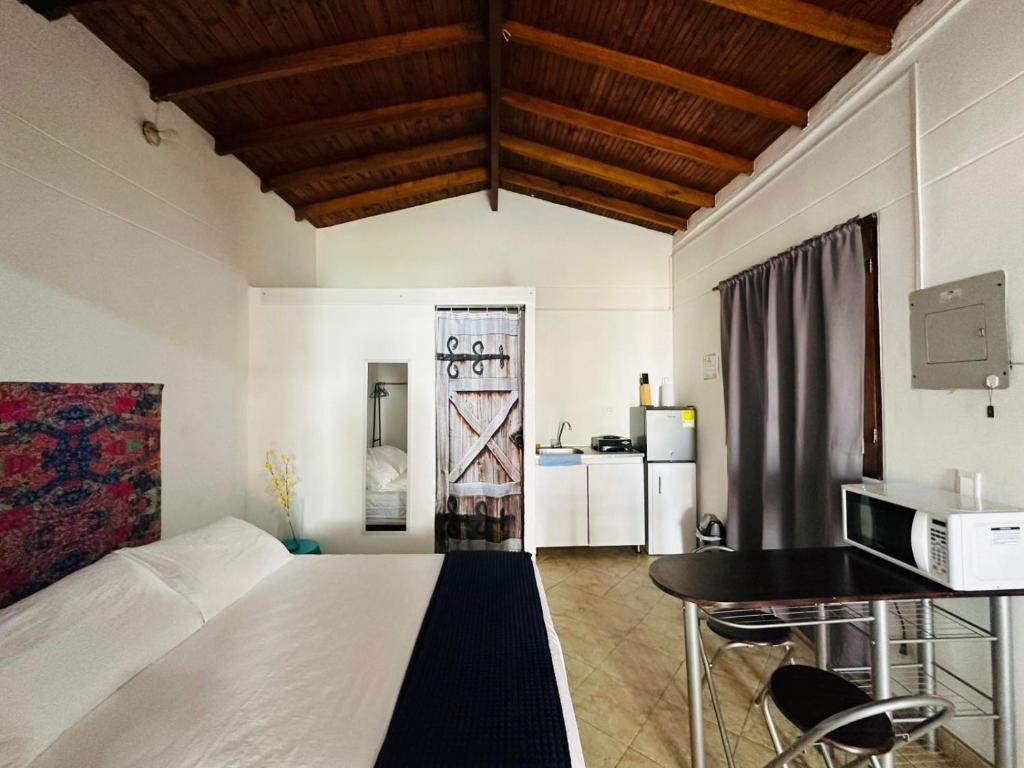 een slaapkamer met een bed en een tafel en een keuken bij Aloja-T en Apartaloft amoblado en Jericó in Jericó