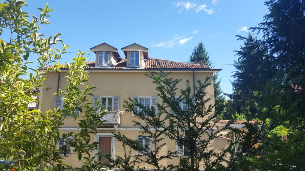 żółty budynek z dwoma oknami na górze w obiekcie Palazzo Colombino Suite&Residence w mieście Giaveno