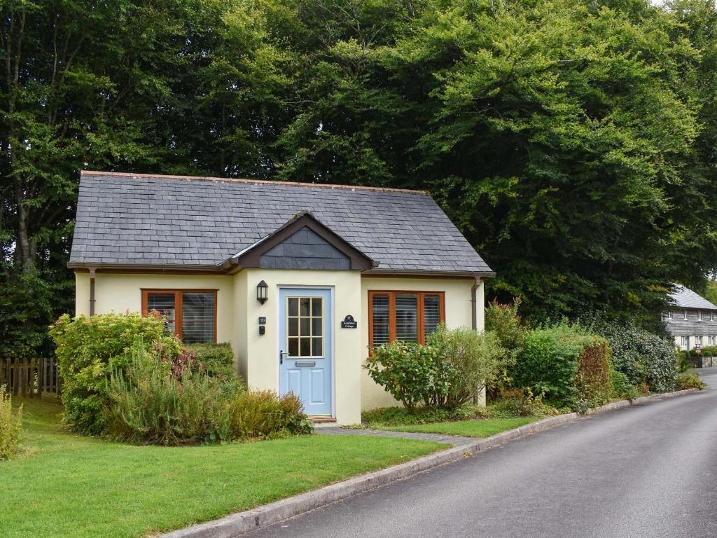a small house with a blue door on a street at Kingfisher Cottage, 20 in Camelford