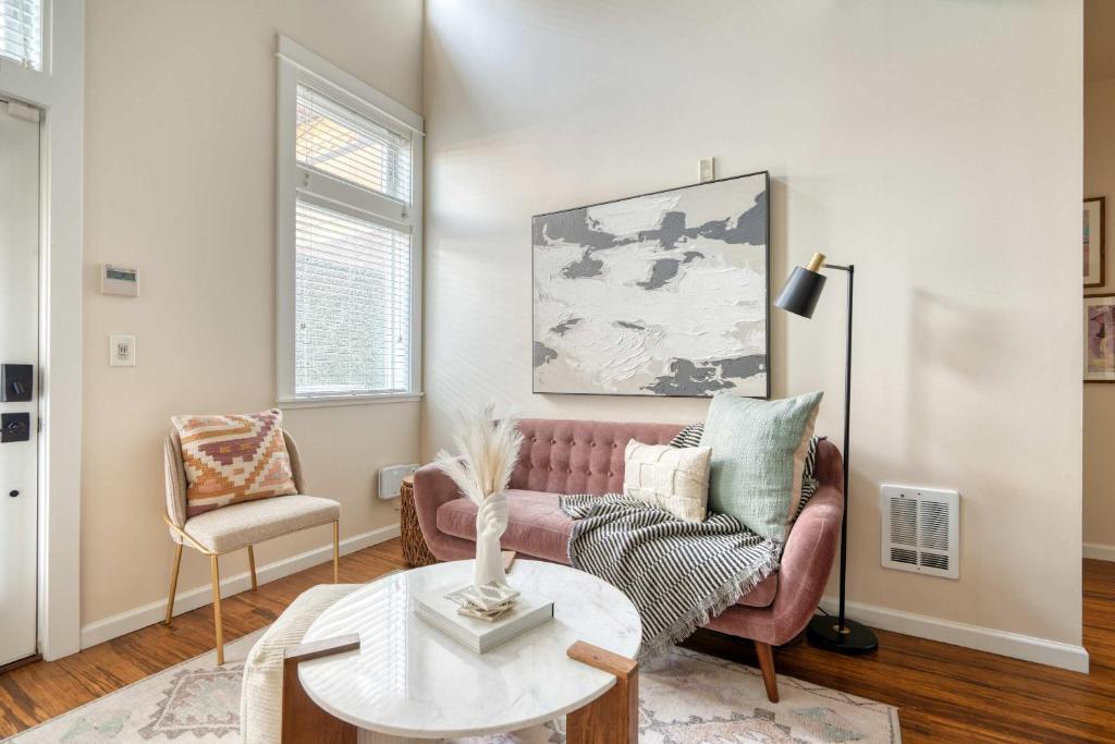 a living room with a pink couch and a table at Chic Loft Retreat in the Heart of NW Portland in Portland