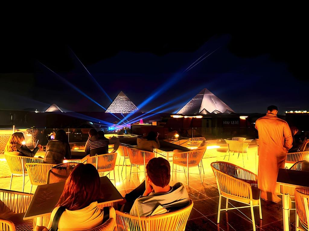 a group of people sitting in chairs at night at Pyramids MagiC View Hotel in Cairo