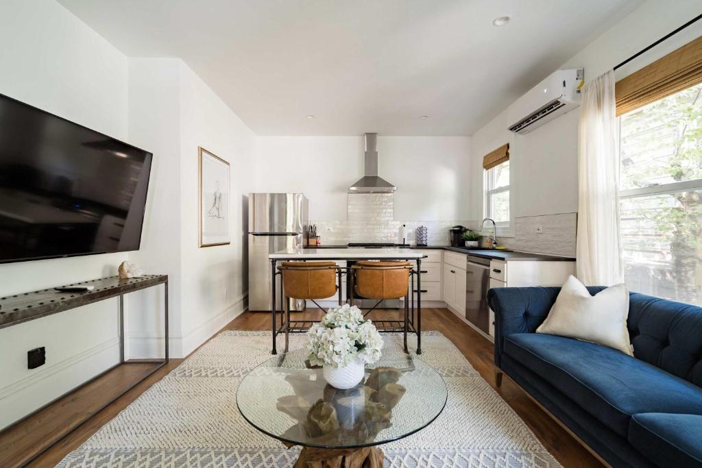 a living room with a blue couch and a table at Stay Portland - The Câlin Suite - Posh Local Boutiques & Eateries in Portland