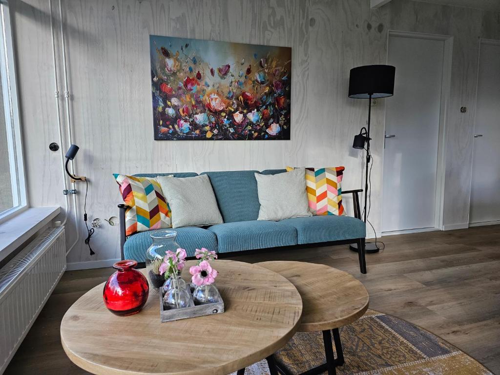 SchoonlooにあるBungalow de Kievitの青いソファとテーブルのあるリビングルーム