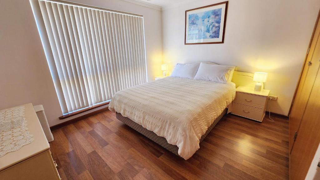 une chambre avec un lit et une grande fenêtre dans l'établissement Hello House, à Safety Bay