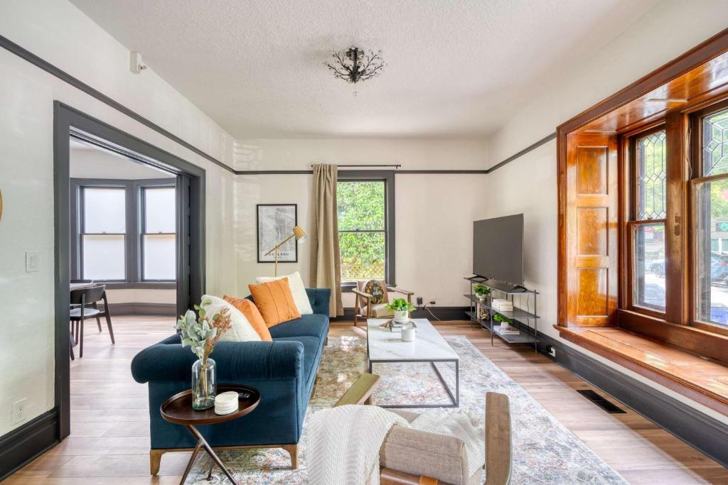 ein Wohnzimmer mit einem blauen Sofa und einem Tisch in der Unterkunft Stay Portland - Luxury Living on NW 23rd Ave, Walk Score 99 in Portland