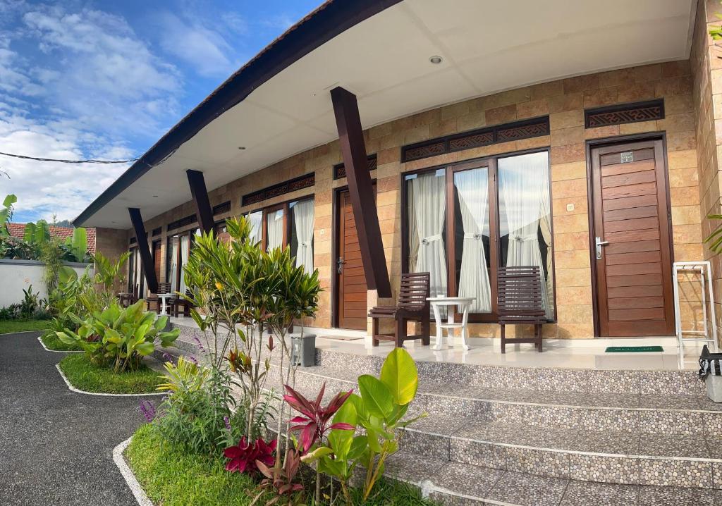 a house with chairs and a table in front of it at Hotel Segara in Kubupenlokan