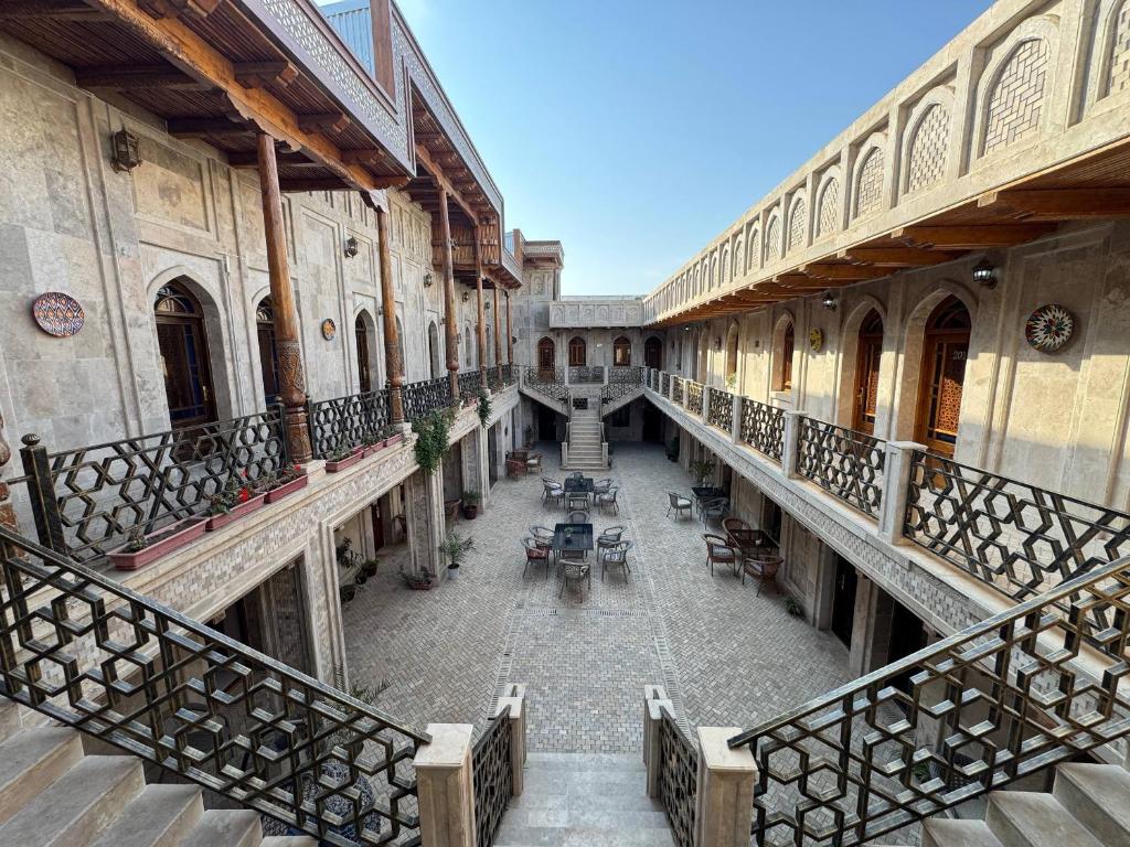 Un patio vacío en un edificio antiguo con mesas. en AMIRAN Boutique, en Bukhara