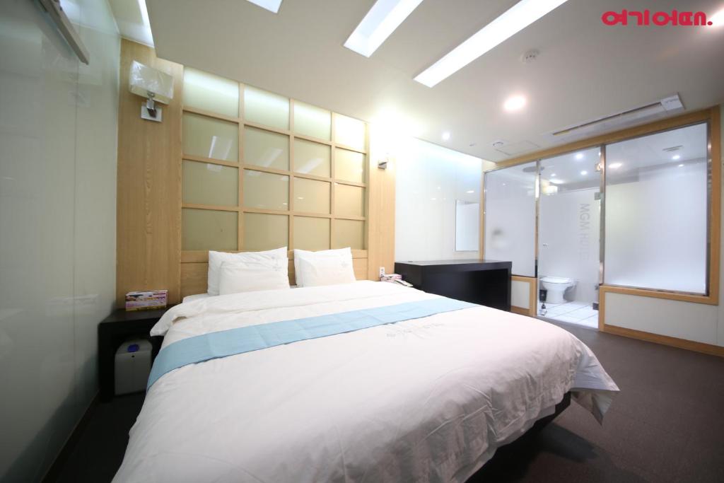 a bedroom with a large white bed in a room at Nampo MGM Hotel in Busan