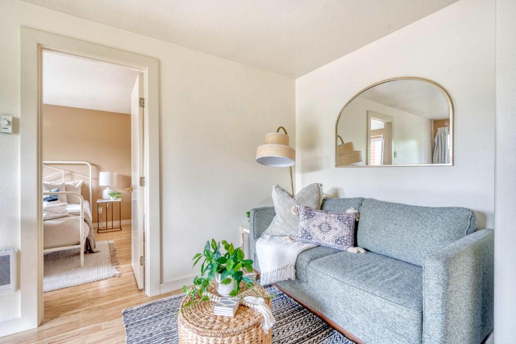 a living room with a blue couch and a mirror at Stay Portland - Adorable Bright 1 Bed Near OHSU in Portland