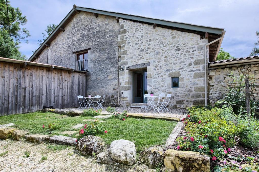 una casa de piedra con un jardín delante de ella en La Grange d'Oustaud, en Vérac