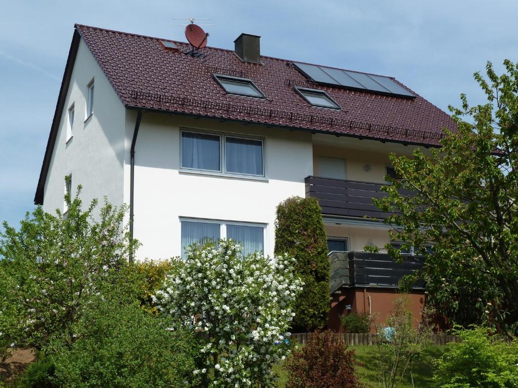 ein weißes Haus mit rotem Dach und einigen Bäumen in der Unterkunft Haus Burgblick in Neuhaus an der Pegnitz