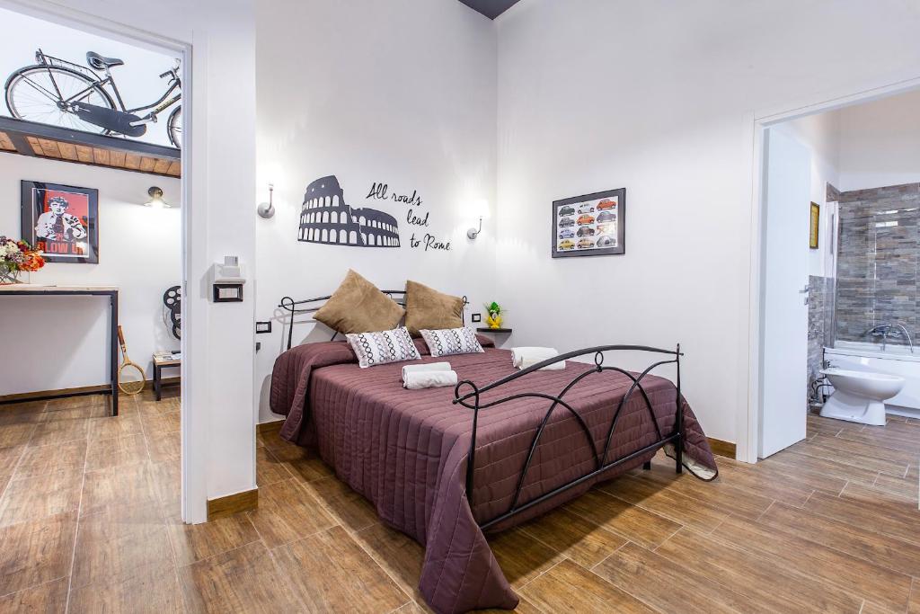 um quarto com uma cama e uma casa de banho com uma bicicleta na parede em Del Falco Boutique Rooms San Pietro em Roma