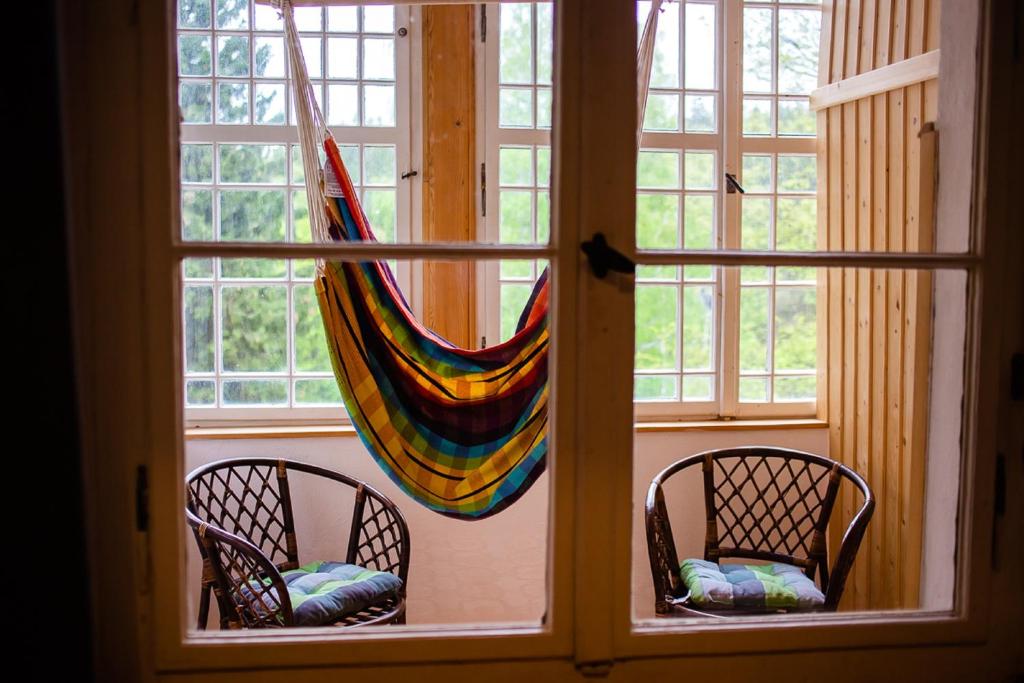 a room with two chairs and a hammock in a window at Hostel Krokus in Karpacz
