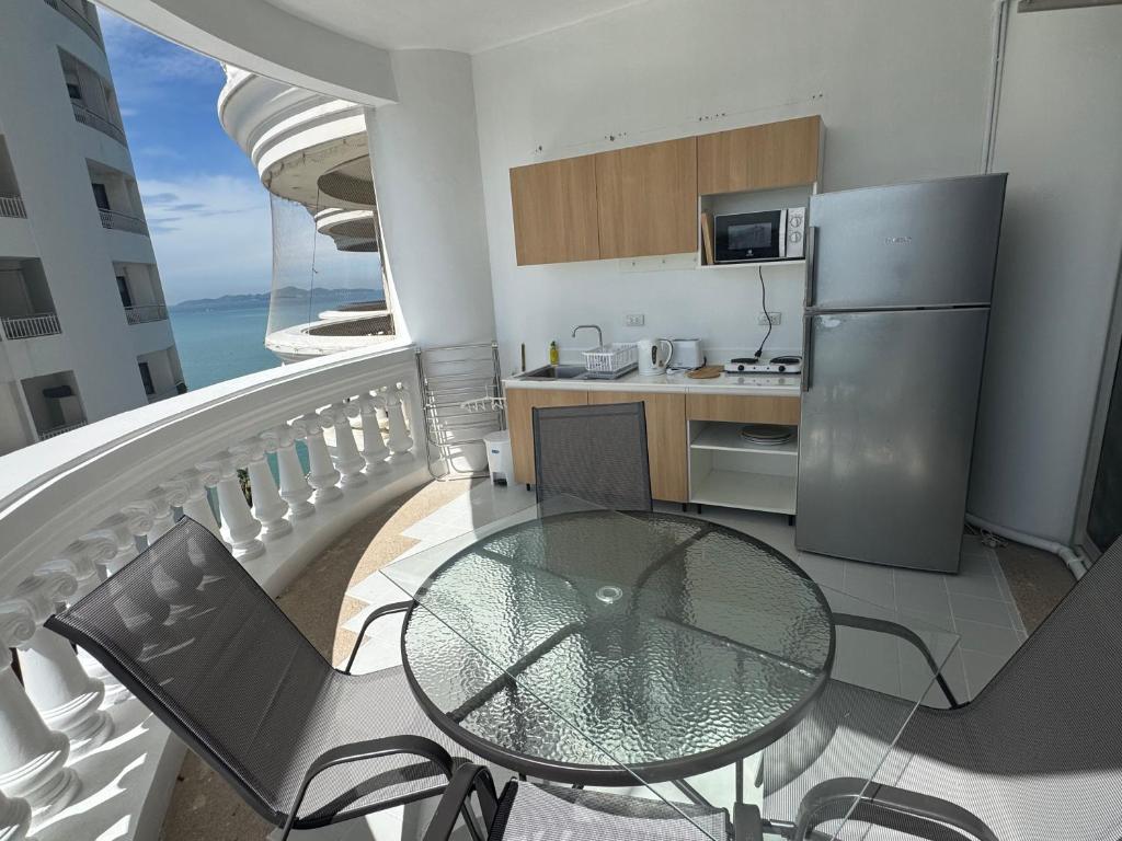 Un balcón con mesa y sillas y una cocina. en Sky Beach Sea view, en Norte de Pattaya