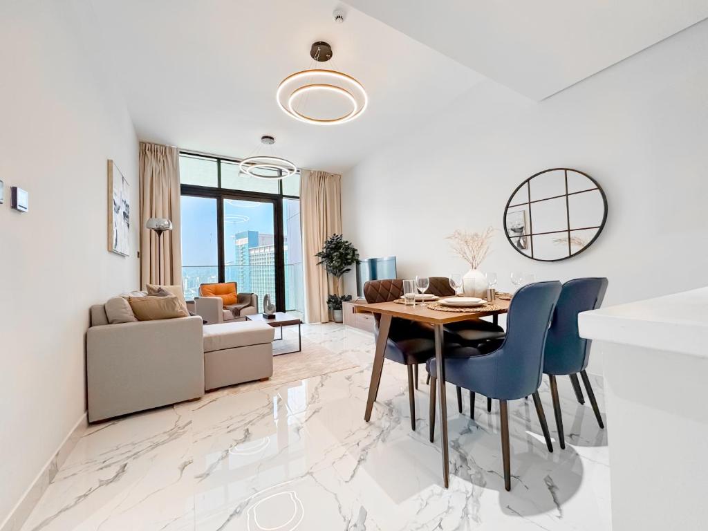 a dining room and living room with a table and chairs at Vista Grande Luxury 3br In Reem By Ayla in Abu Dhabi