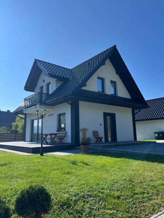 a white house with a black roof at Dom na Borówkowym Wzgórzu in Paleśnica