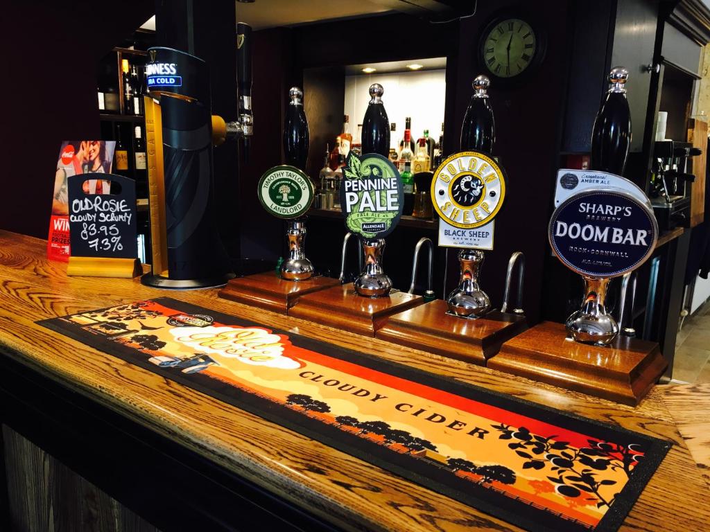 The Dyvels Inn في كوربريدج: بار مع مجموعة من زجاجات البيرة