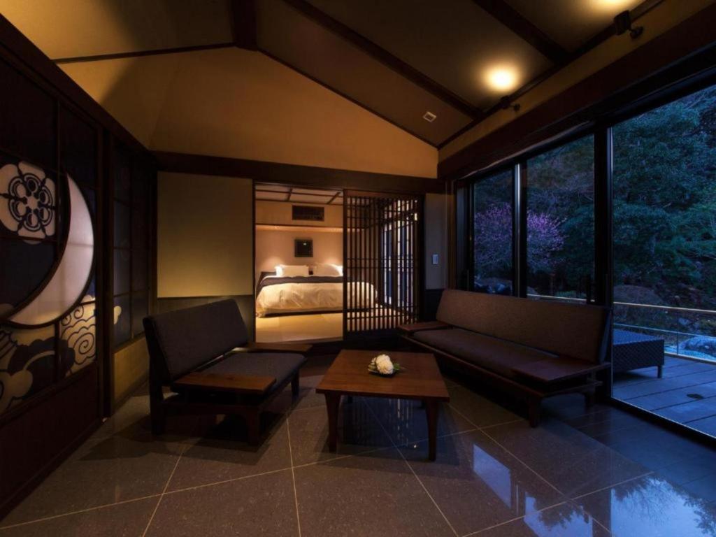 a room with a couch and a bed and a table at Tsukiyominoza in Ise