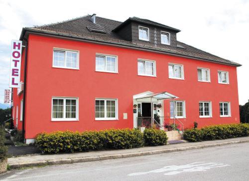 a red house on the side of a street at Salzburg Hotel Lilienhof in Salzburg