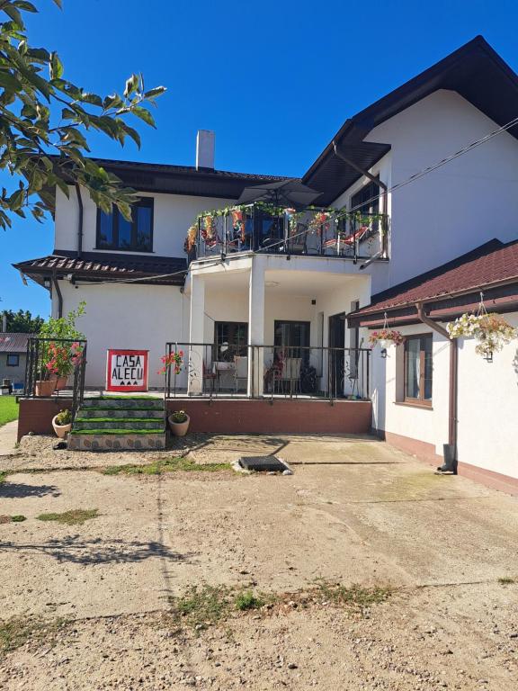 a white house with a balcony on top of it at Casa Alecu in Urecheşti