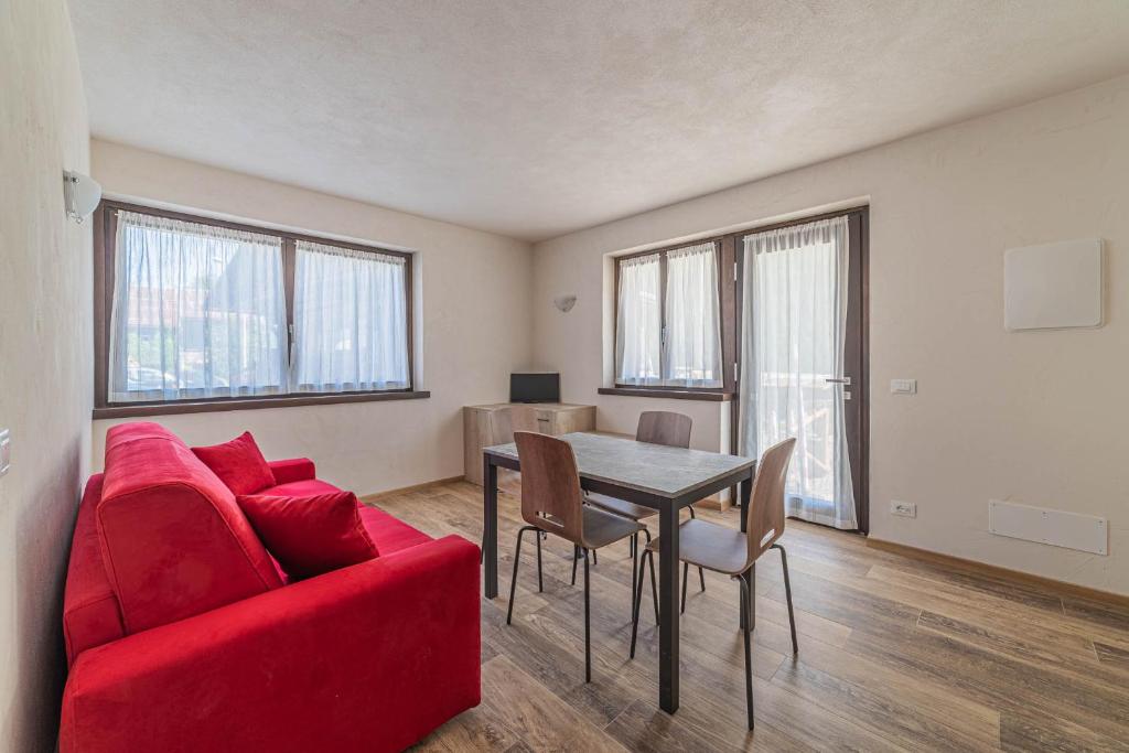 a living room with a red couch and a table at Casa Scola in Falcade