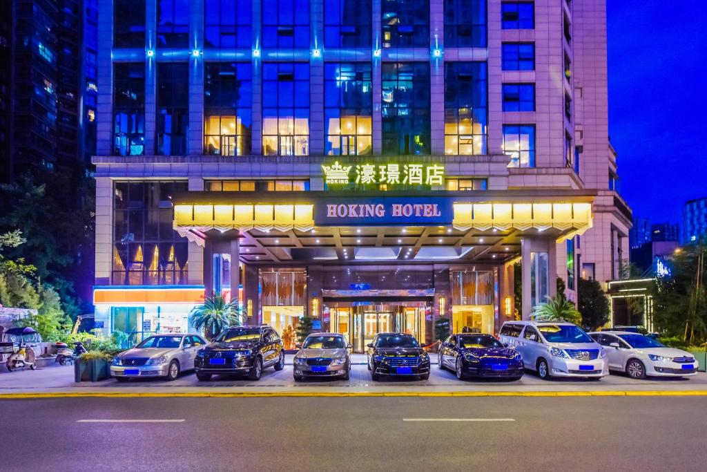 un groupe de voitures garées devant un bâtiment dans l'établissement Moon Crescent Hotel (Chengdu West Steition Culture Palace Metro Stetion Branch), à Supoqiao