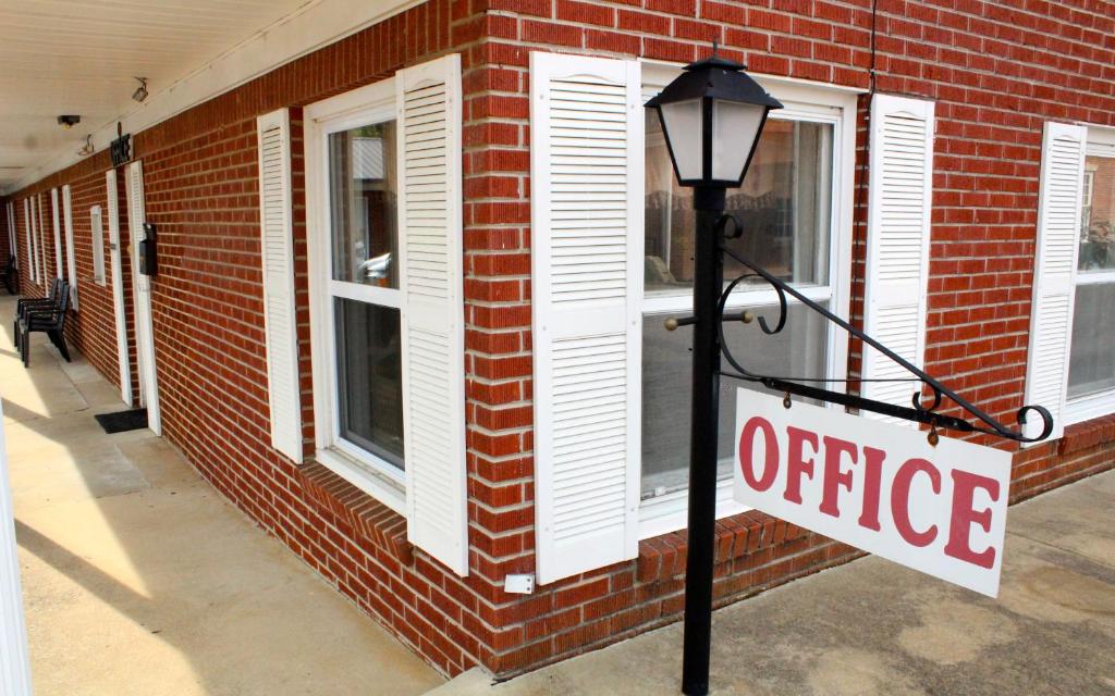 un cartel en una luz de la calle frente a un edificio de ladrillo en Savannah Motel en Savannah