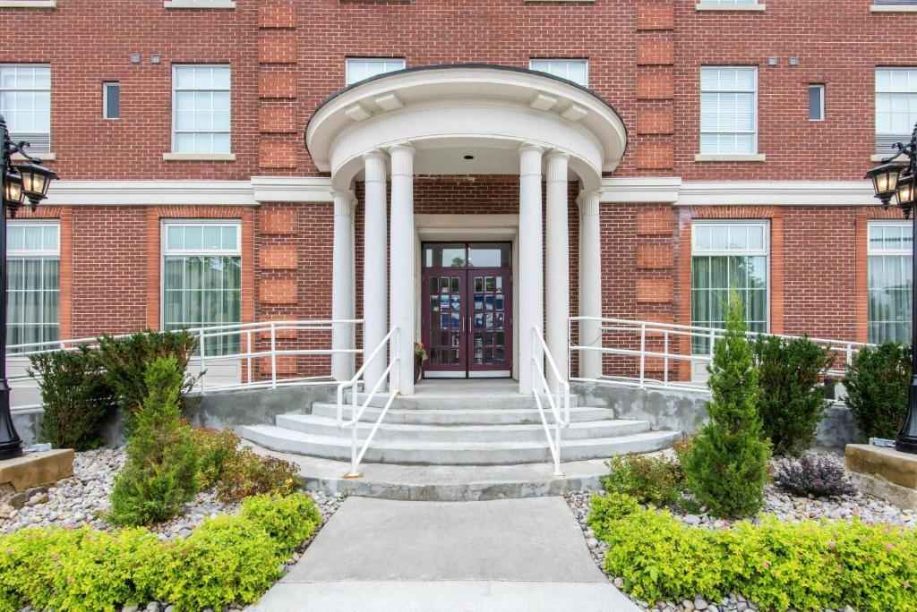 a brick building with a front door and stairs at The Champlain Waterfront Hotel, an Ascend Collection Hotel in Orillia