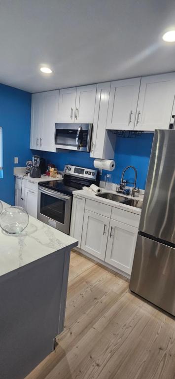a kitchen with white cabinets and stainless steel appliances at Work & Lake Guest house at Airport in SeaTac