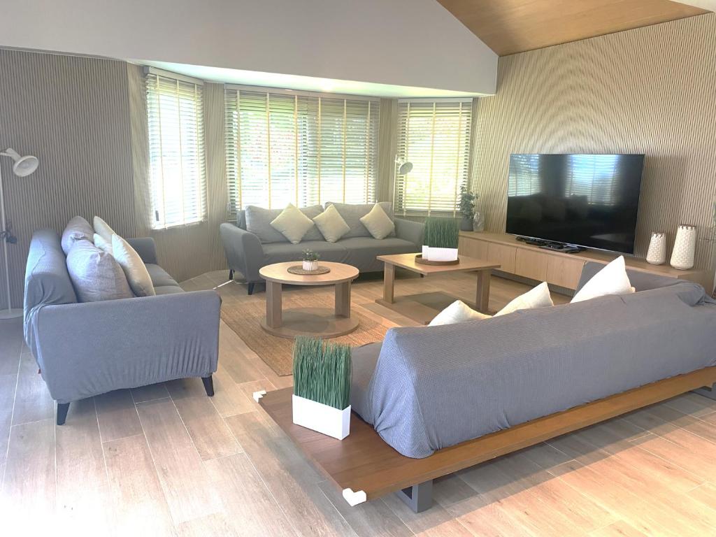 a living room with a couch and a tv at B89 3BR Hillside Seaview Escape in Ban Ko Kok