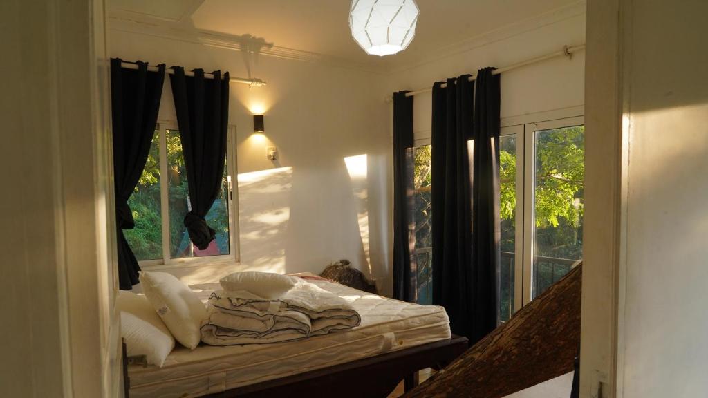 a bedroom with a bed with a mirror and a window at Tree Nature Resort in Hali Ela