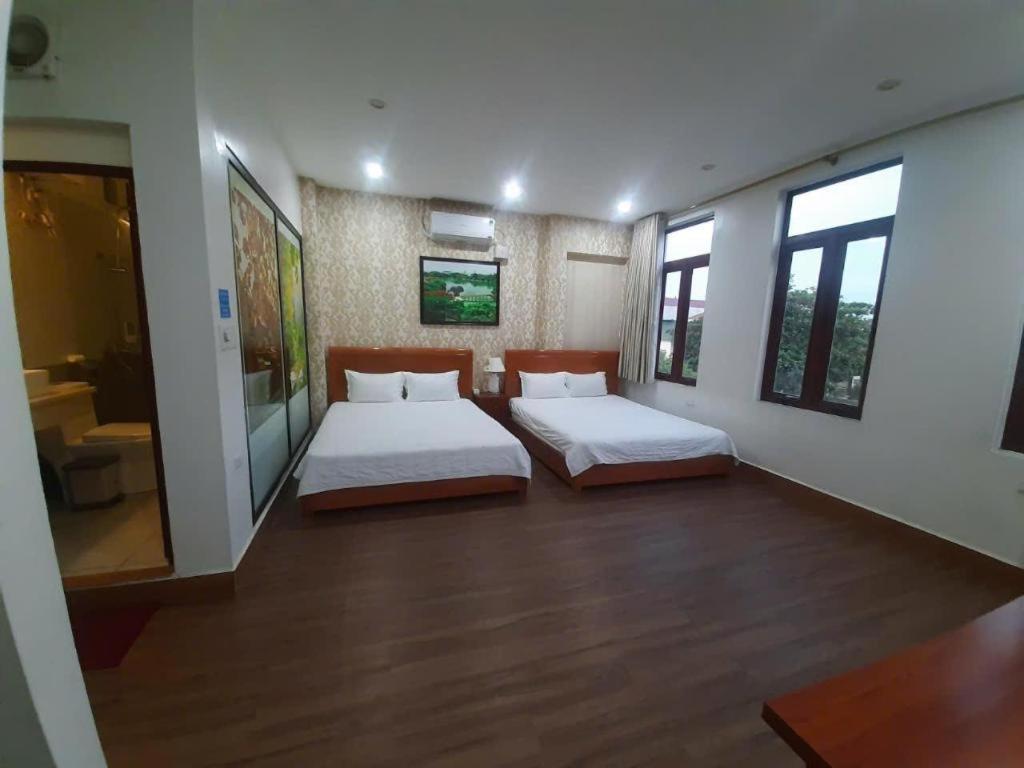 a large room with two beds and a bathroom at Luxury Airport Hotel & Spa in Phu Lo Dong