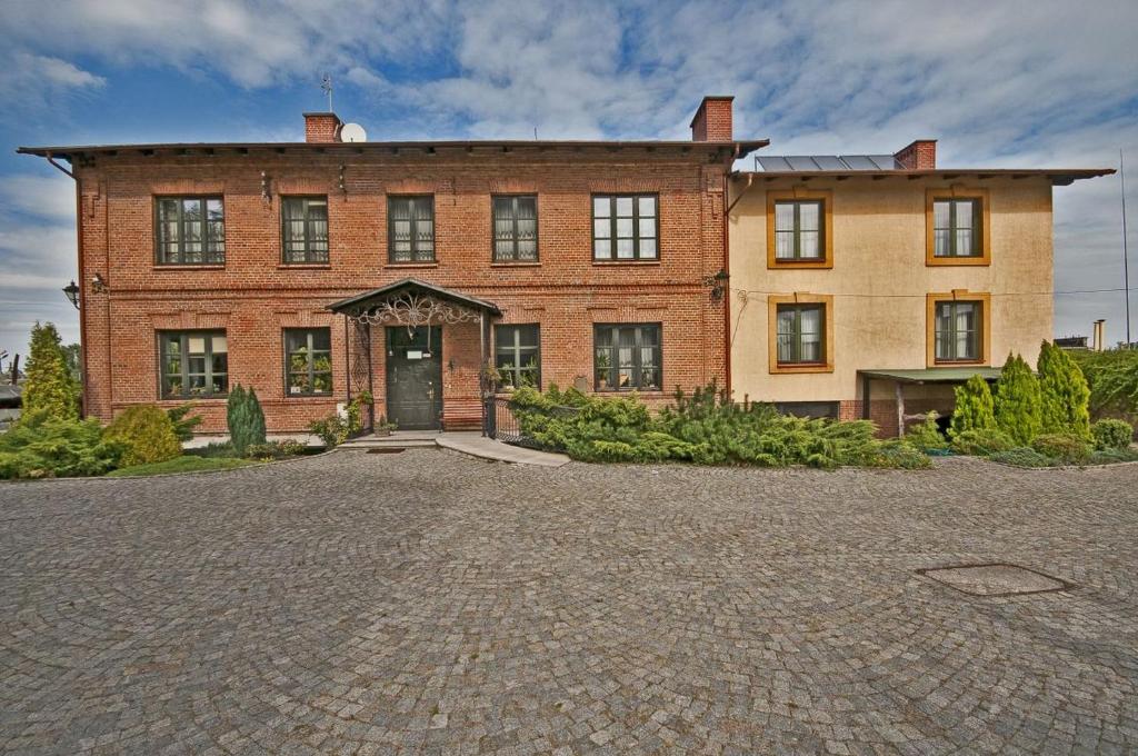 una gran casa de ladrillo con una entrada delante de ella en Hotel Restauracja Pod Parowozem, en Ostrowiec Świętokrzyski