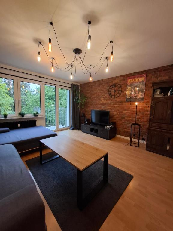 a living room with a table and a brick wall at Like at Home in Gorzów Wielkopolski