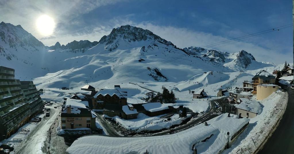 a village covered in snow with mountains in the background at Petit studio lumineux vue montagne in La Mongie