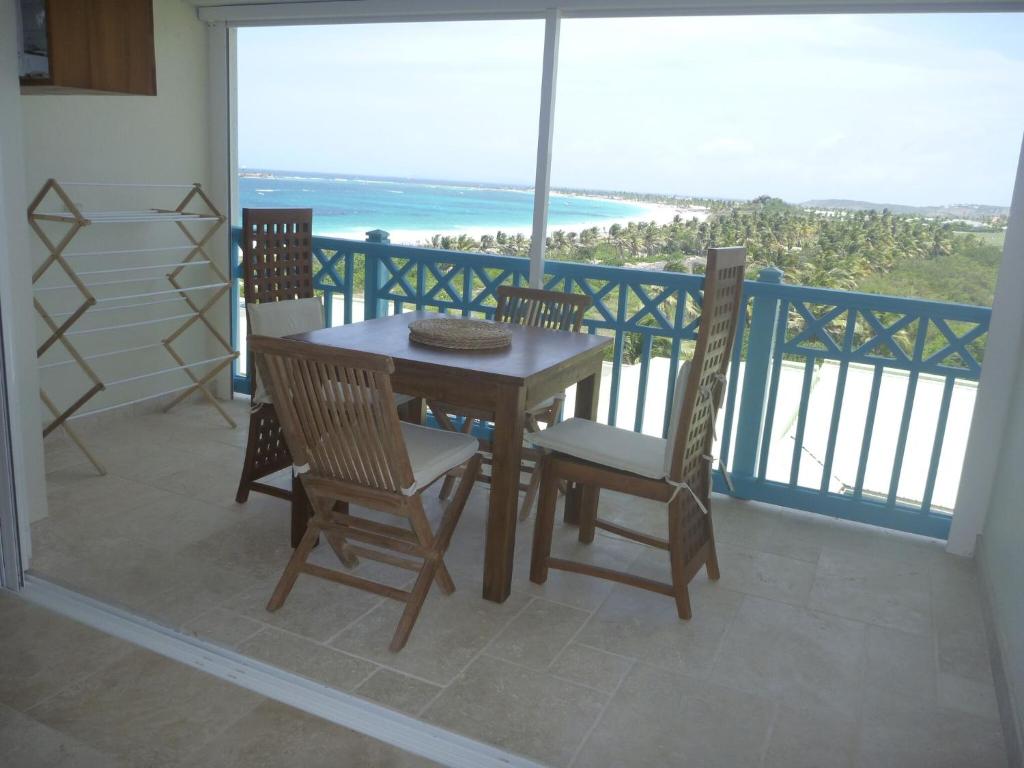 una mesa y sillas en un balcón con vistas al océano en European Luxur Tortola 5318, en Cul de Sac