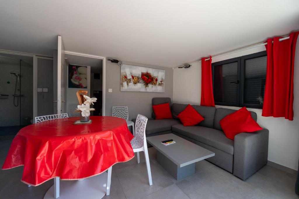 a living room with a couch and a table with red pillows at SUPERBE VILLA VUE MER JUSQU'A 14 COUCHAGES La LONDE LES MAURES Entre HYERES et Le LAVANDOU 4 Etoiles PISCINE CHAUFFEE in La Londe-les-Maures