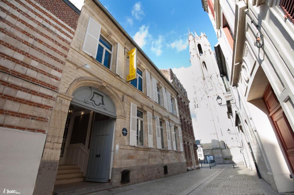 a building on a street with a clock tower at Hotel Le Prieuré et La Résidence in Amiens